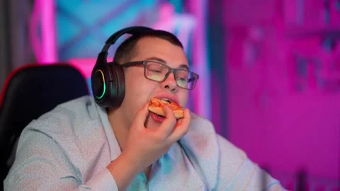 The Fat gamer plays at the computer and eats a burger and pizza. A Thick program Видео 220421237