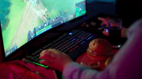 The Fat gamer plays at the computer and eats a burger and pizza. A Thick program 動画素材 220423840