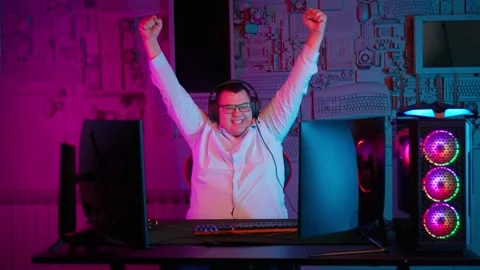 The Fat gamer plays at the computer and eats a burger and pizza. A Thick program Vídeos de archivo 220423959