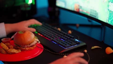 The Fat gamer plays at the computer and eats a burger and pizza. A Thick program Stock Footage 220424123