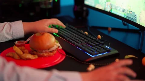 The Fat gamer plays at the computer and eats a burger and pizza. A Thick program Stock Footage 220424207