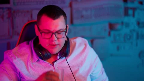 The Fat gamer plays at the computer and eats a burger and pizza. A Thick program Stock Footage 220424363