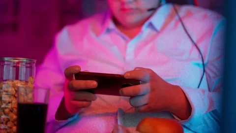 The Fat gamer plays at the computer and eats a burger and pizza. A Thick program Stock Footage 220424400
