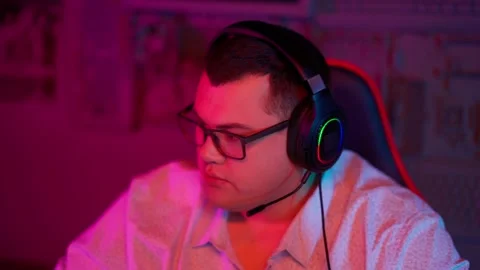 The Fat gamer plays at the computer and eats a burger and pizza. A Thick program 動画素材 220545969