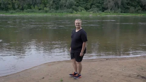 Fat guy is jumping on the background of the pond. Stock Footage 131114271