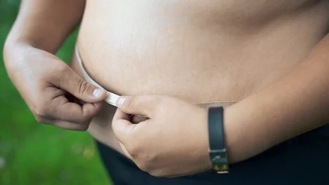 Fat guy is measuring his stomach Stock Footage 129518673