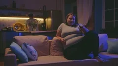 Fat girl sitting on sofa during watch TV, Stock Video