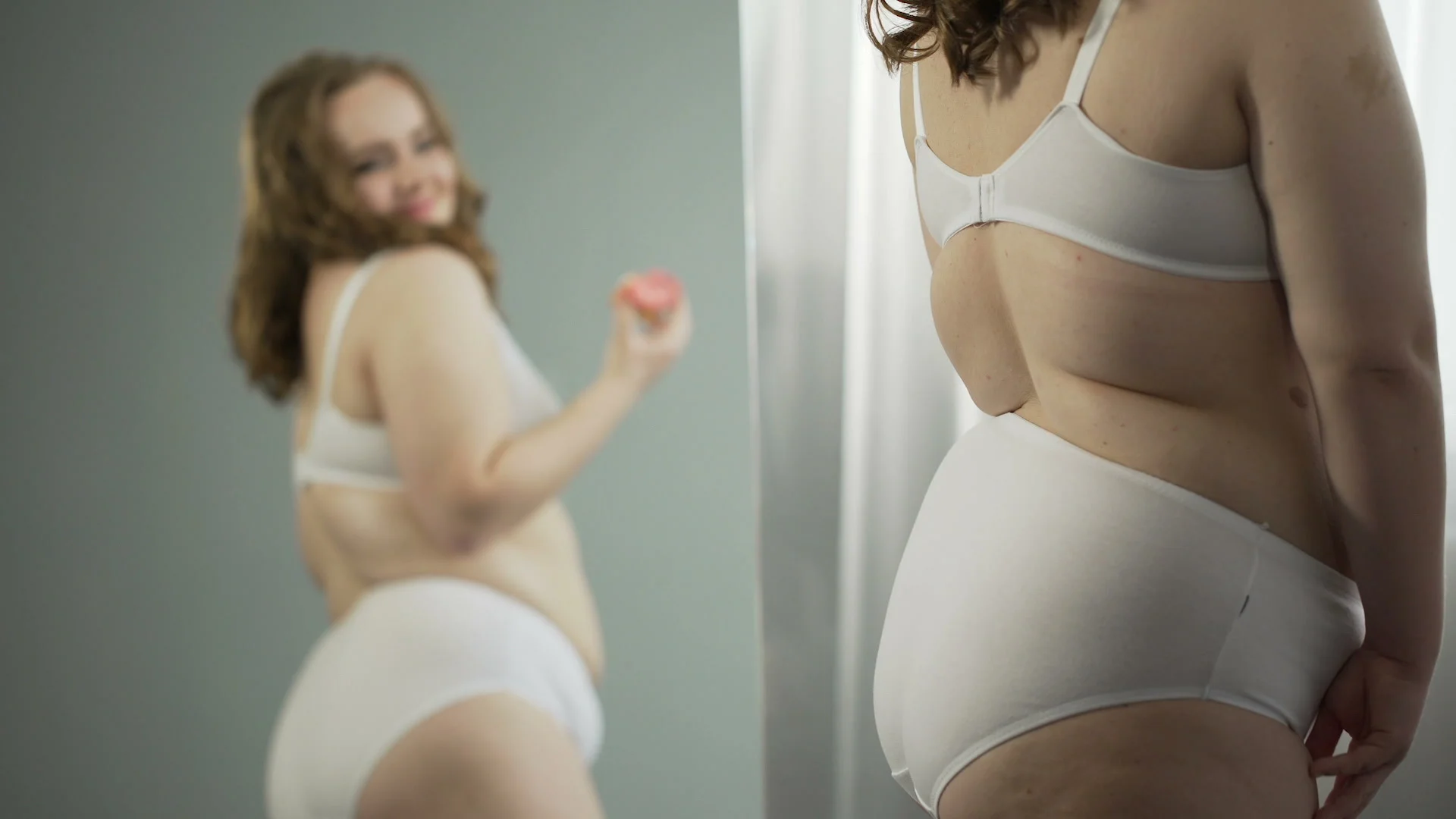 aecd8c65781 Fat lady in underwear looking at her mirror reflection and enjo...