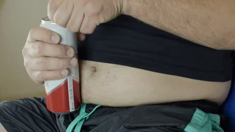 The fat man drinks beer. A man opens a can of beer. Bad food, gluttony. Close-up Vídeo Stock 94880062