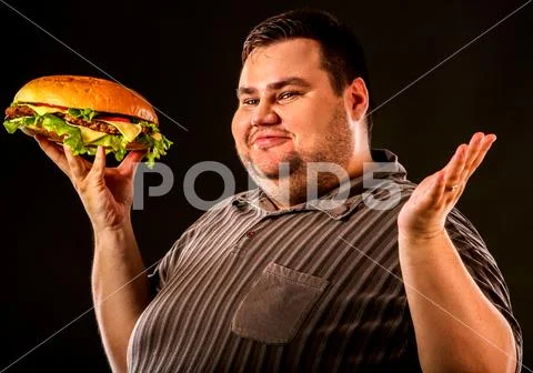 Fat man eating fast food hamberger. Breakfast for overweight person. Stock Photos
