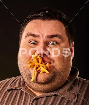 Fat man eating fast food french fries for overweight person. Stock Photos