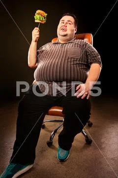 Fat man eating fast food hamberger. Breakfast for overweight person. Stock Photos