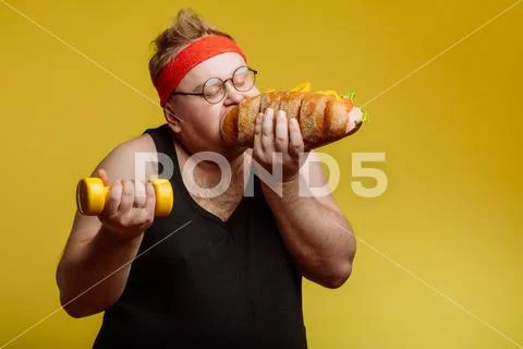 Fat man eating fast food hamberger Stock Photos