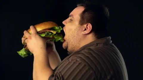 Fat man eating hamberger fast food . Breakfast for overweight person. Stock Footage