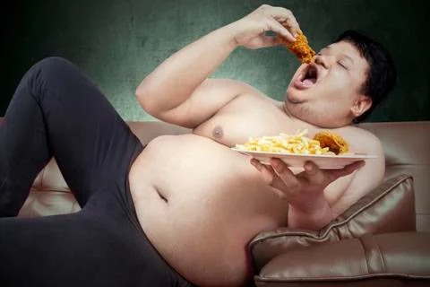Fat man eats junk food Stock Photos