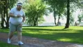 Fat man feels heart attack while running, obese girl helping him, friend support HD Footage