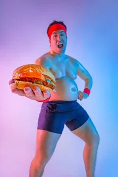 Fat man with gives away hamburger for lose weight and become a slim athlete. Not Stock Photos