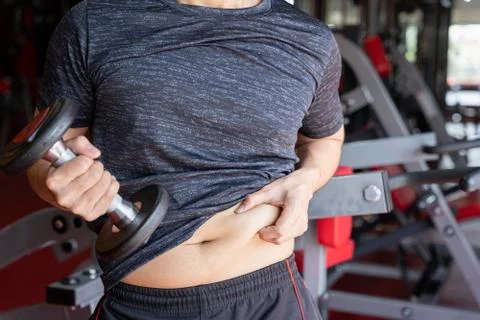 Fat man holding dumbbell and excessive fat belly, overweight fatty belly at f Stock Photos