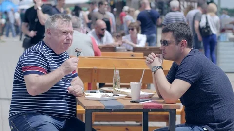 Fat man munch piece of meat from plastic utensils on street, overweight people Stockbeeldmateriaal 77319358