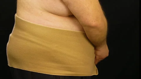 Fat Man Puts On Lumbar Support Belt Stock-Footage 154546499