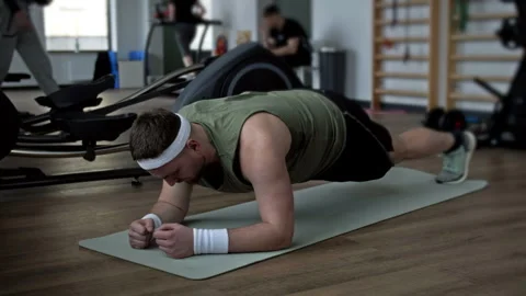 Fat man struggles to do plank exercise at the gym, and then falls exhausted on Stock Footage 249168098