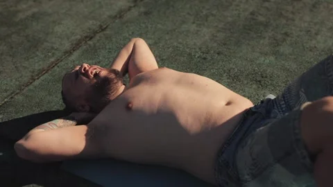 Fat man is trying to pump his abs outdoors, determined to lose weight and get Stock Footage 307062761