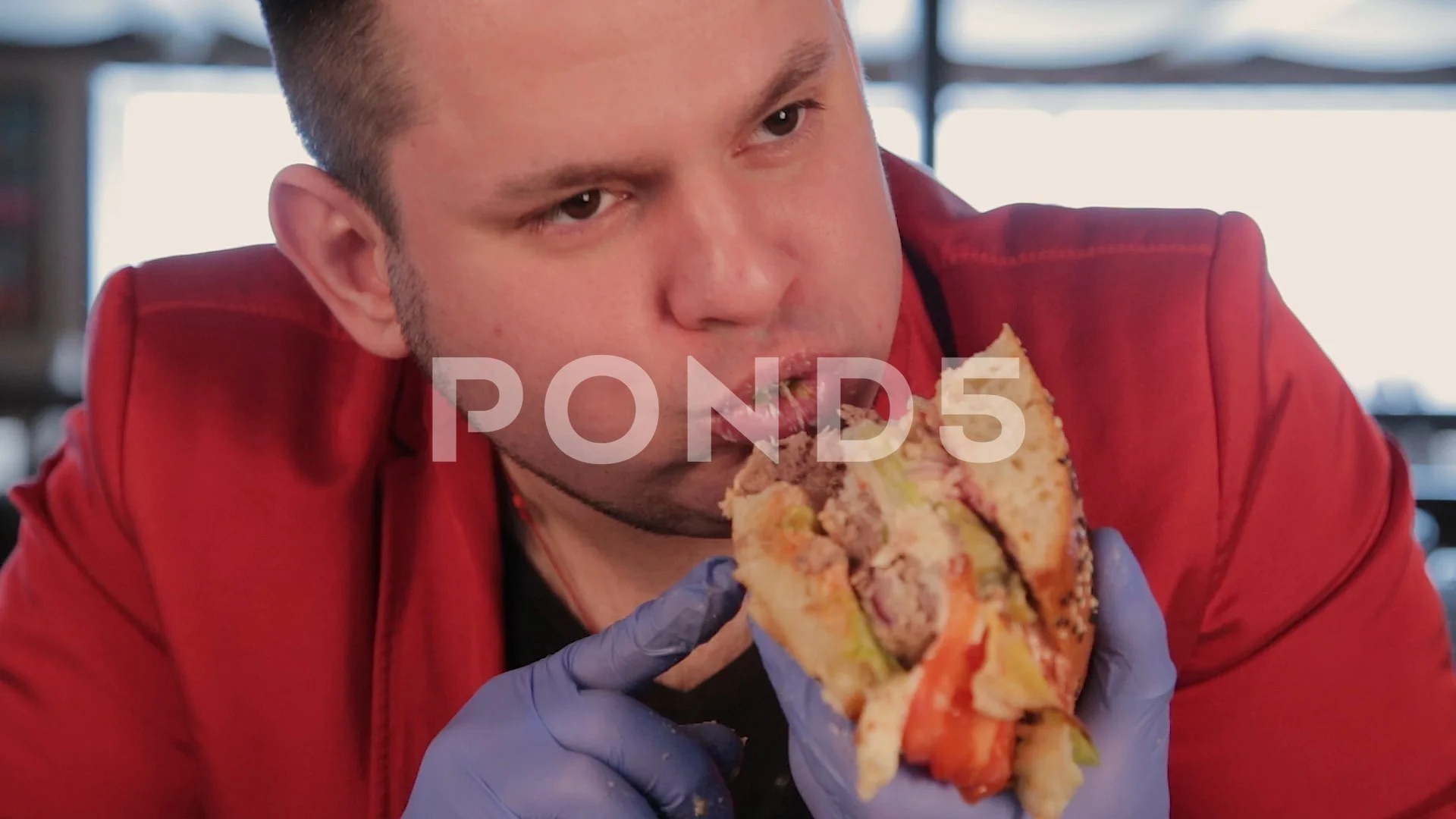 Fat man is ugly eating a big burger.