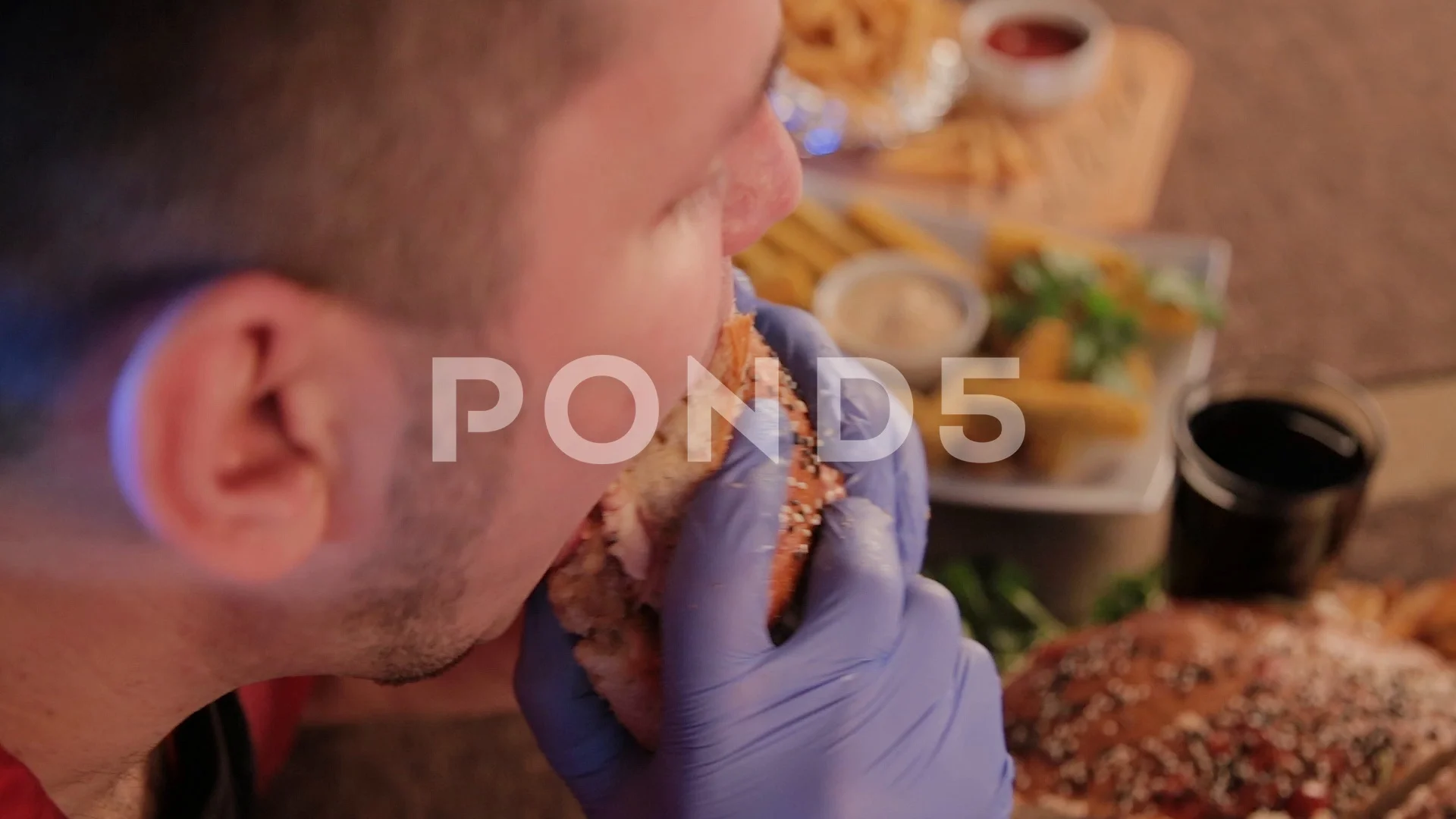 Fat man is ugly eating a big burger.