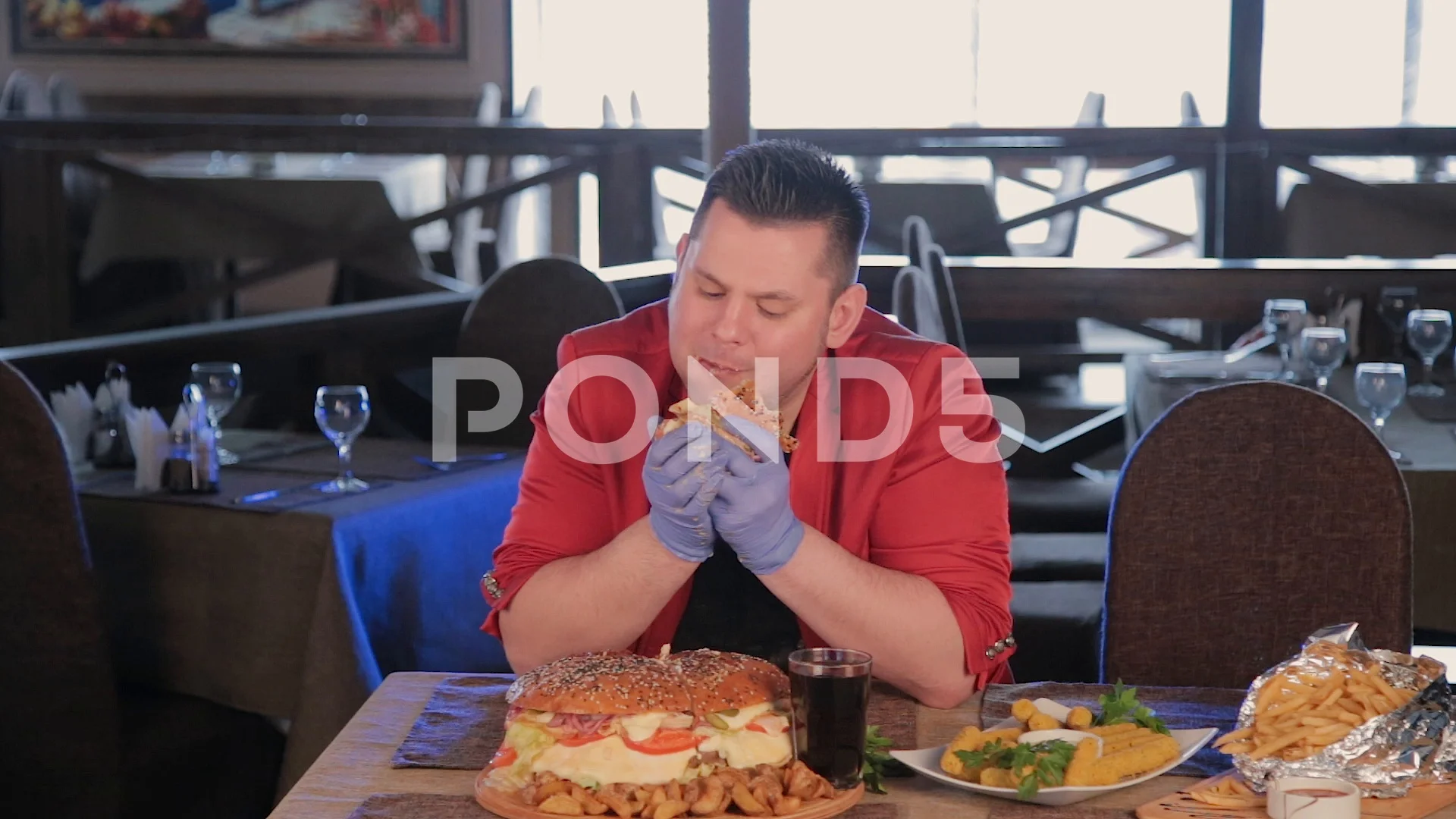 Fat man is ugly eating a big burger.