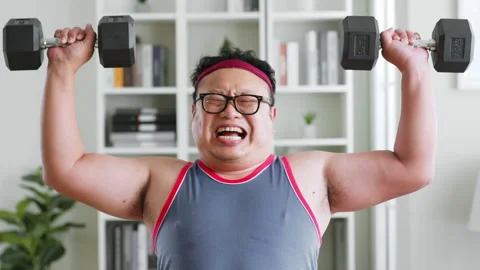 Fat middle-aged asian man in sportswear workout with dumbbell at home Stock Footage 231538050