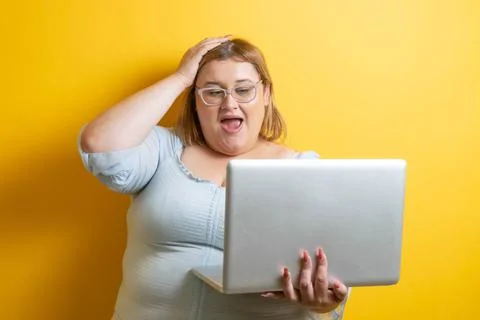 Fat model with laptop making scared or surprised face Stock Photos