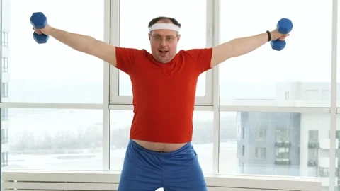 Fat nerd man with funny face doing exercise with dumbbells. Funny athletic man Stock Footage 170075110