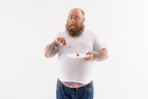 Fat surprised guy eats healthy food Foto stock