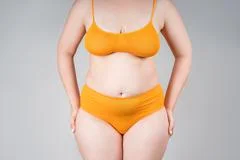 Fat woman in underwear, overweight female body on gray background