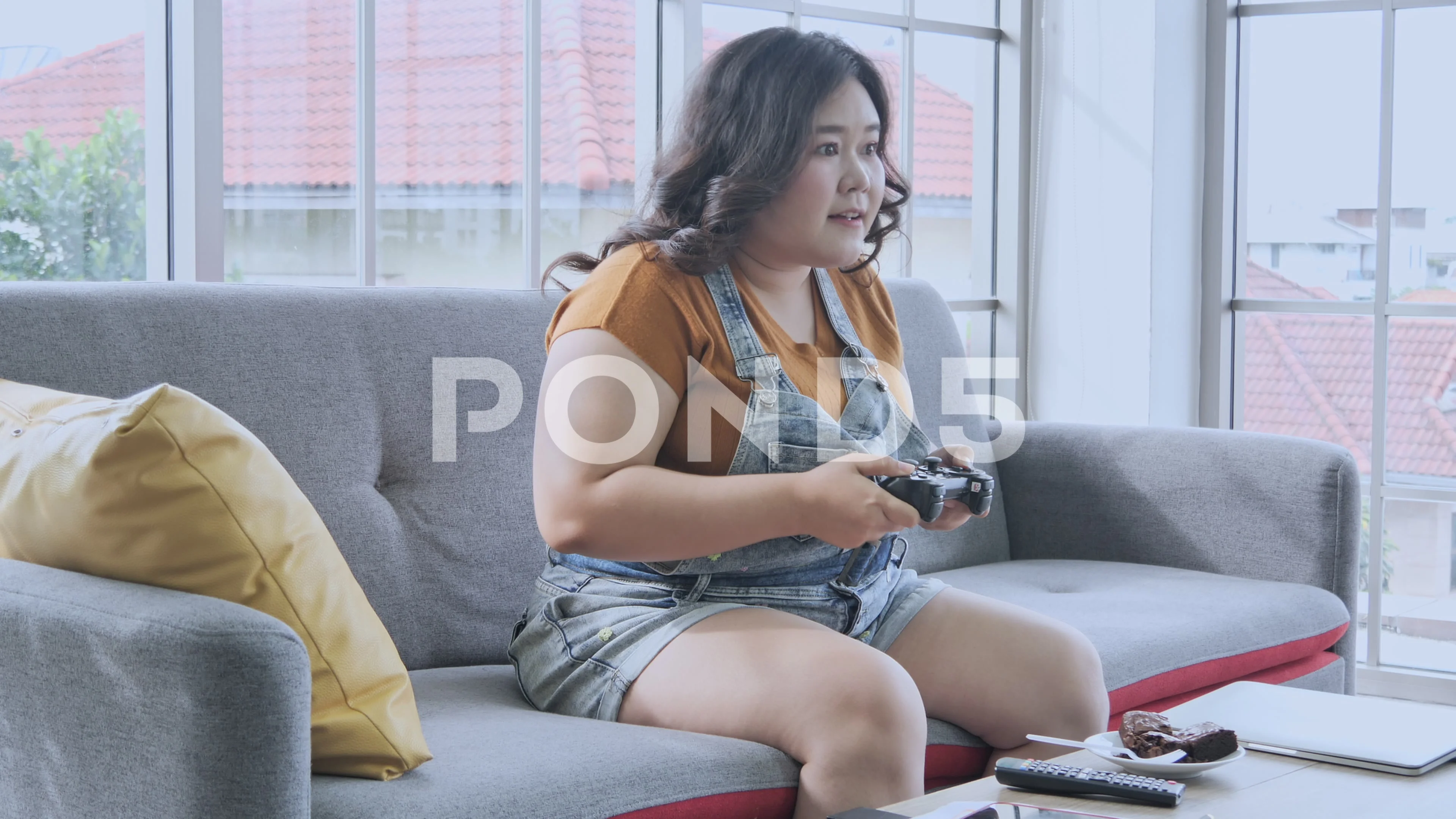 Fat woman playing games happily at home | Stock Video | Pond5