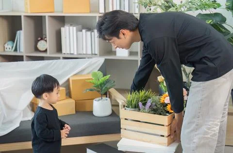 Father and child bonding while unpacking flowers at home Stock Photos