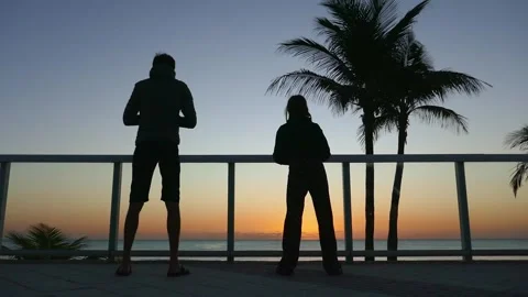 Father and child doing exercises on the ocean shore at sunrise Stock Footage 269719824