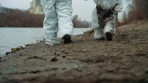 Father and child explore contaminated waterside in work gear. Environmental 動画素材 342748468