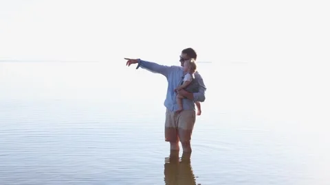 Father and child exploring shallow water on a bright sunny day Stock Footage 345365390