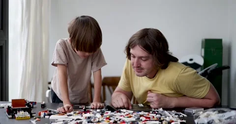 Father and child play constructor sitting at the table Stock Footage 219471004