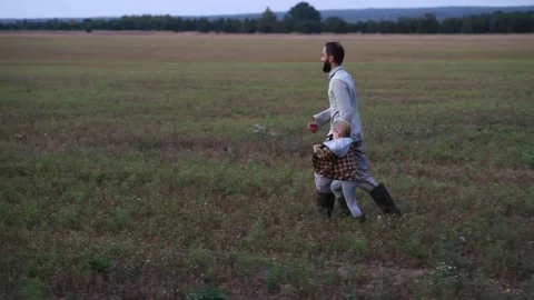 Father and child running through a field and sharing a joyful moment 库存影片 300096933