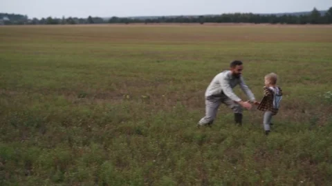 Father and child running through a field and sharing a joyful moment Видео 300096997