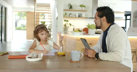 Father and child sitting at kitchen table, raising fingers asking help, man with Stock Footage 341852614