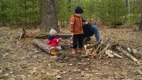 Father and children digging the ground in the forest to prepare a future camp 스톡 동영상 334601091