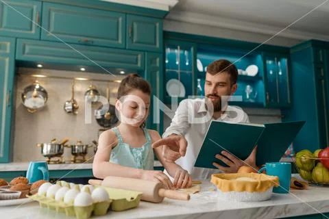 Father and daughter baking pastries in kitchen Stock Photos