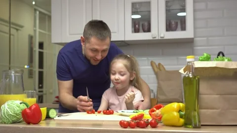 Father and daughter bond while preparing fresh salad ingredients together Stock Footage 307982979