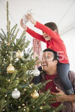 Father and daughter decorating Christmas tree Stock Photos