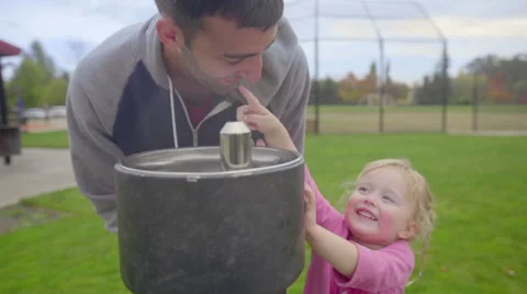 Father and daughter have fun at watering fountain Stock Footage 58491553