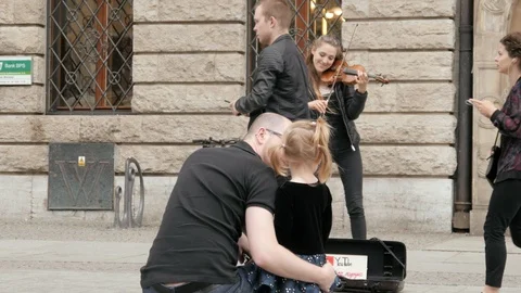 Father and Daughter Kid listening to a Woman Street Musician Playing Violin Stock Footage