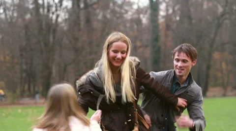 Father and daughter playing around mother in park Stock Footage 59554483